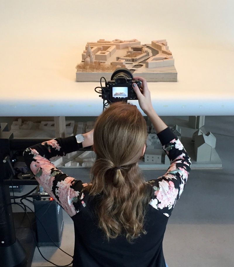 Anna Galinovskaya fotografiert im Modellbau ein Architekturmodell einer Stadt mit einer Kamera.